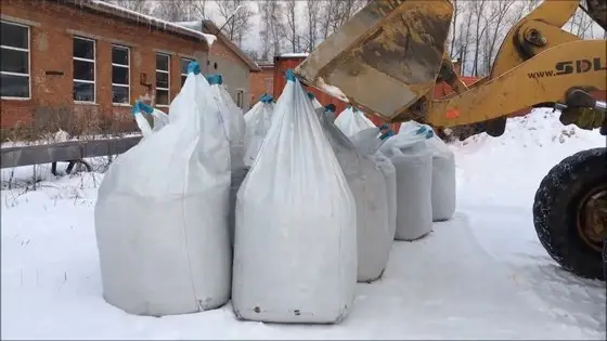 Образец того, как не нужно хранить твердые реагенты Мешки с пескосолью на снегу
